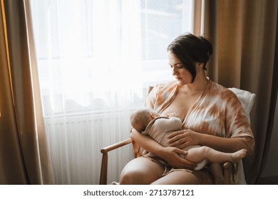 A plus-size new mother sitting near a window holding her infant, a glass of water and a snack plate on the side table