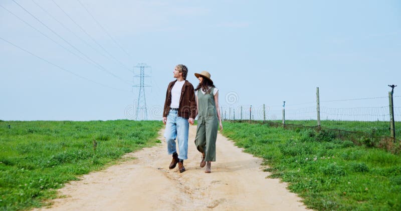Couple walking hand in hand through a sunny farmers market