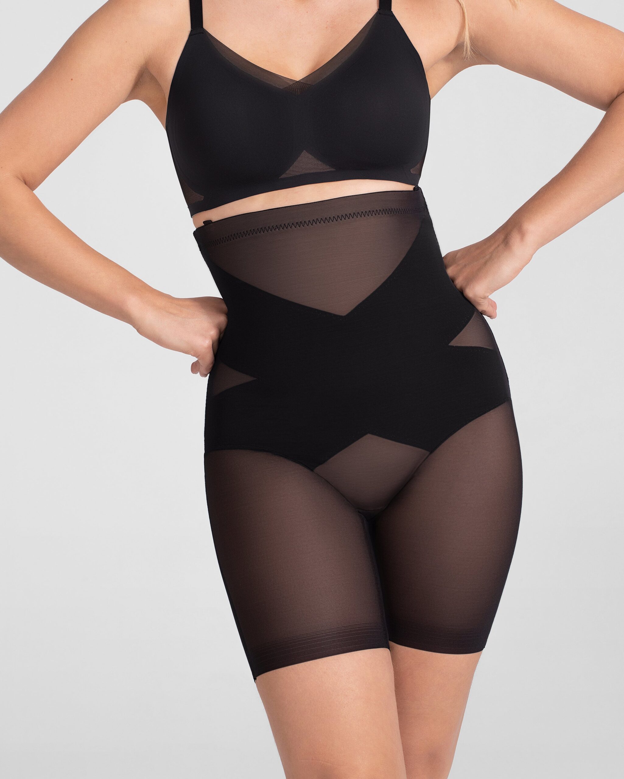 Honeylove SuperPower shorts and sculpting bodysuit in nude and black on a cream backdrop
