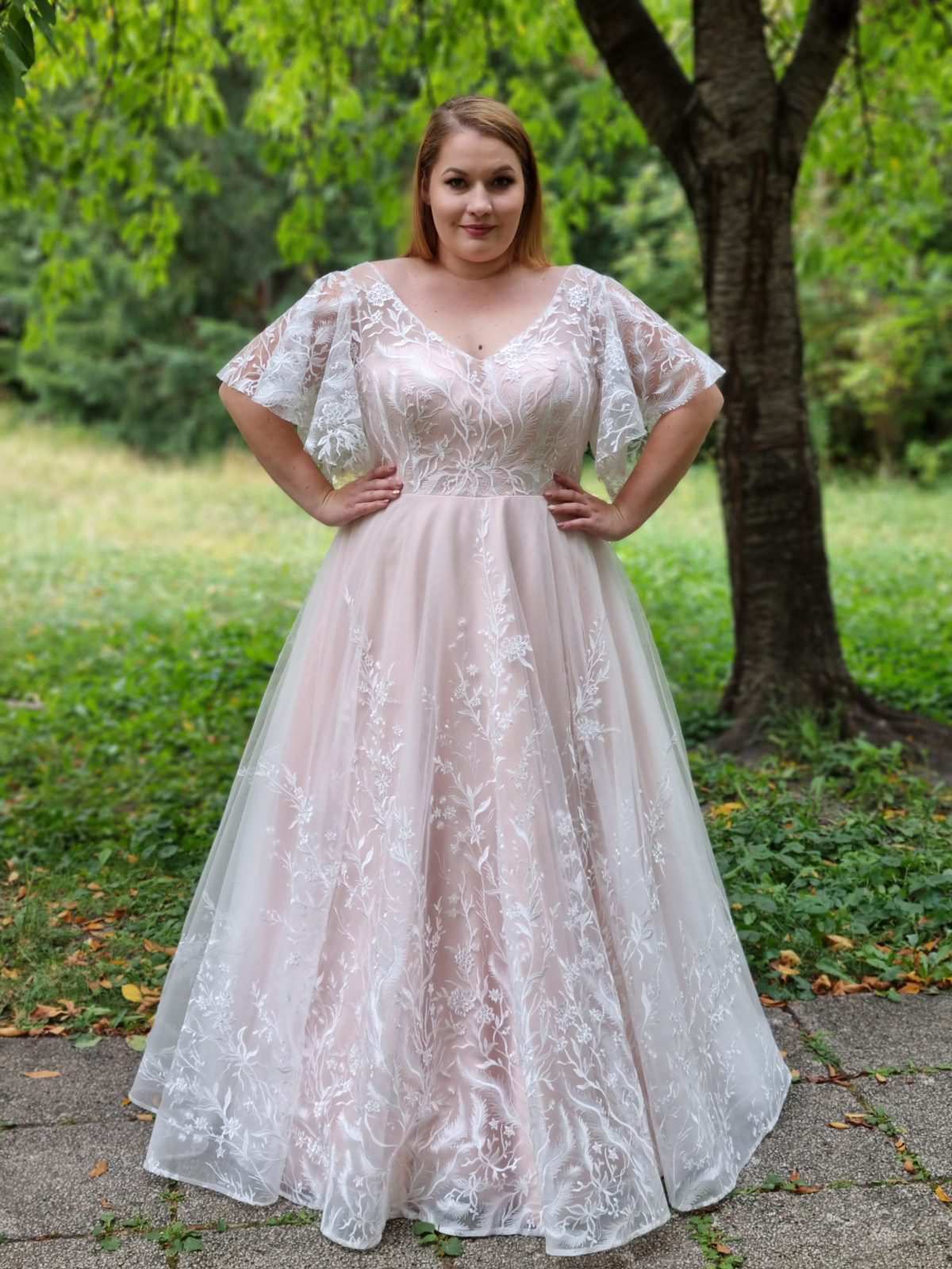Plus-size bride in a budget tier wedding dress in the 400 to 900 dollar range