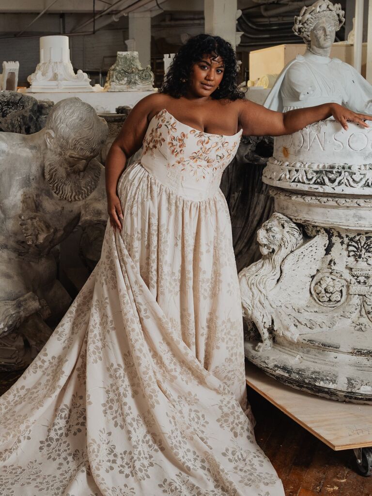 Plus-size bride viewing wedding dress options at multiple price tiers in a bridal boutique