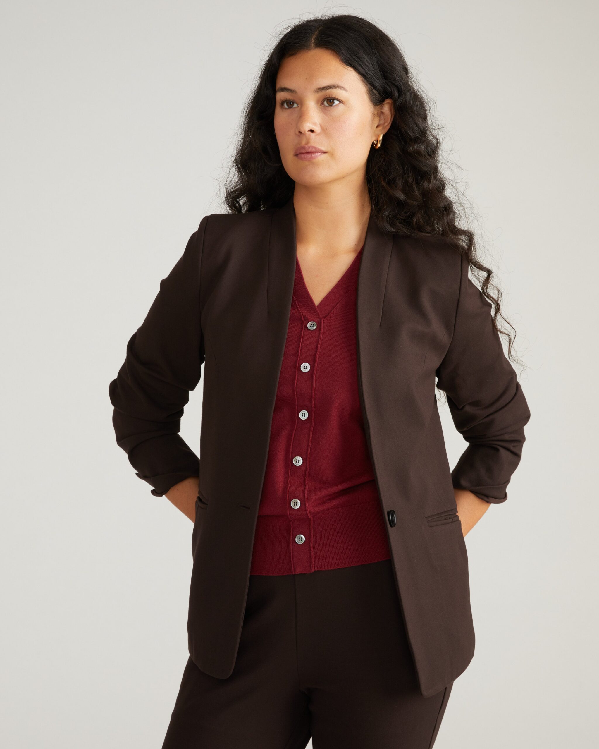 Plus-size candidate in burgundy ponte sheath and camel blazer for in-office first round interview