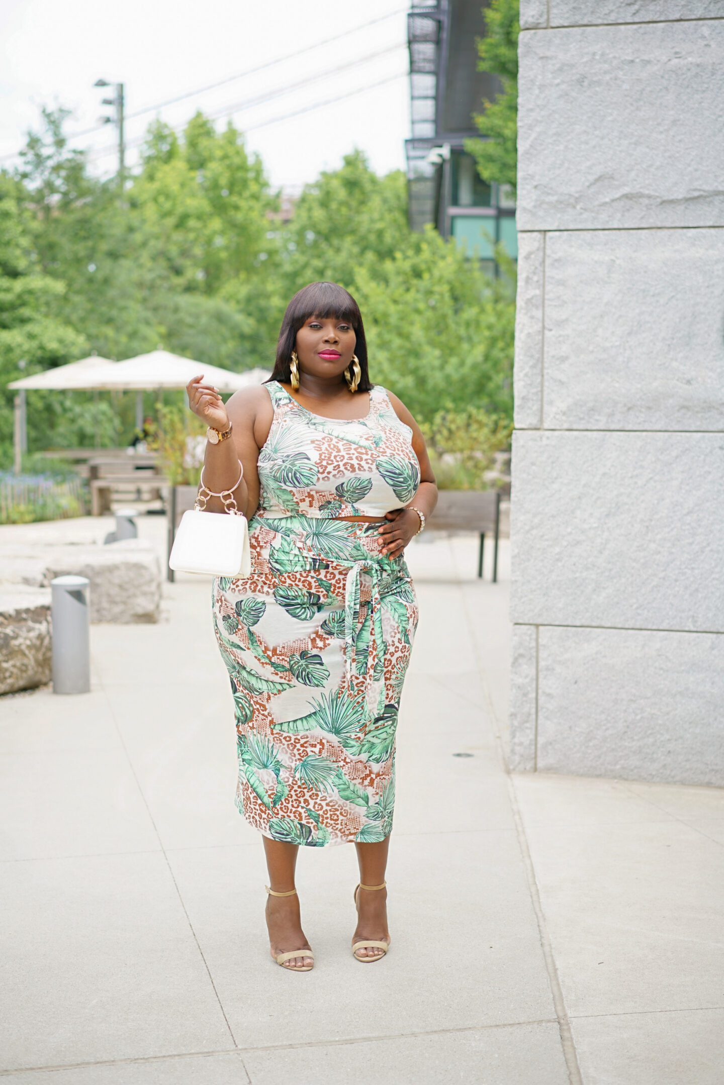 Plus-size woman arriving at a tropical hotel in a stylish dress and sneakers
