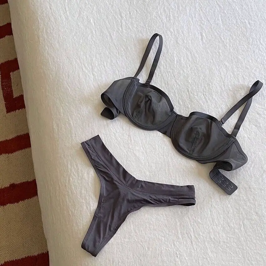 Three Cuup bras in different shades flat lay with measuring tape on linen background