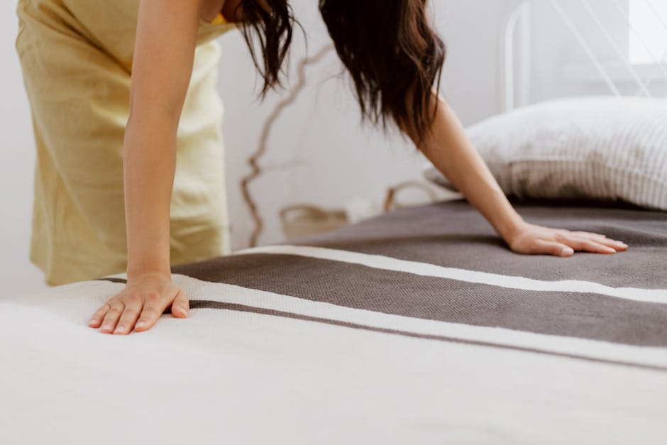 Woman making her bed as part of a 15-minute morning tidying routine