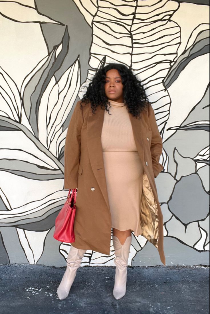 Plus-size Black woman trying on a caramel wool Marina Rinaldi blazer inside the Rome Via del Corso boutique