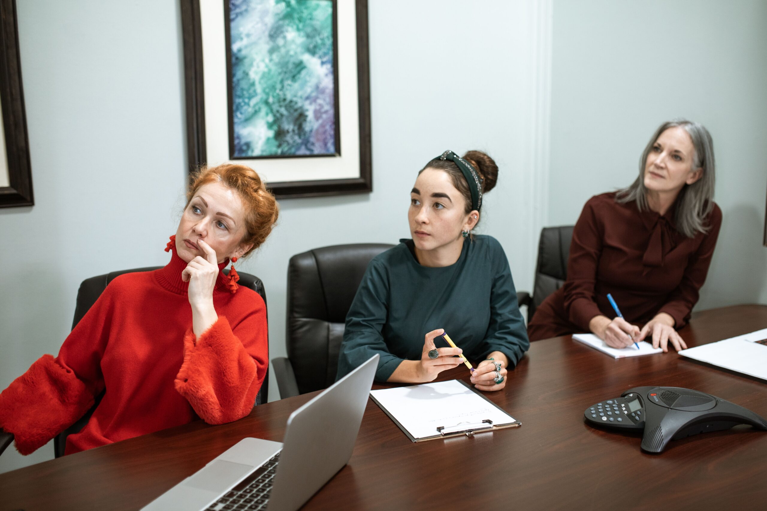 Plus-size woman in business casual seated across a conference room table from an HR coordinator holding a folder of medical documentation during an ADA accommodation conversation
