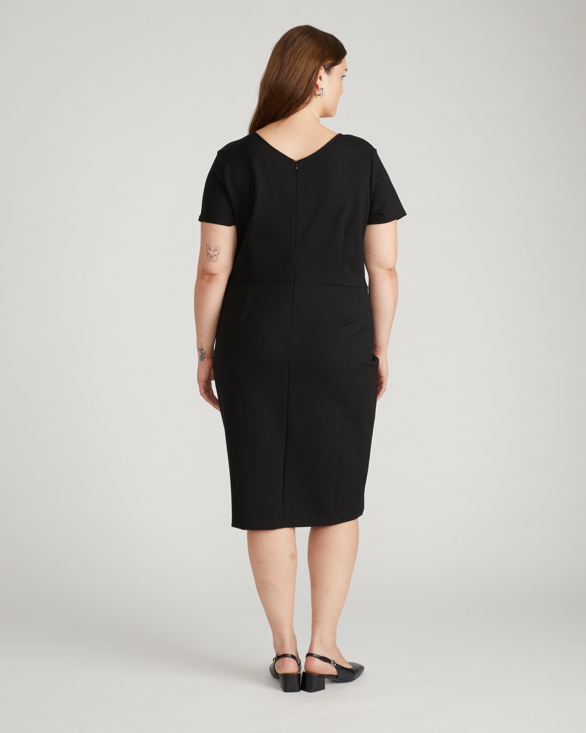 Plus-size woman in a black column dress walking into a wine bar, Universal Standard Bond dress, size 22 first-date outfit