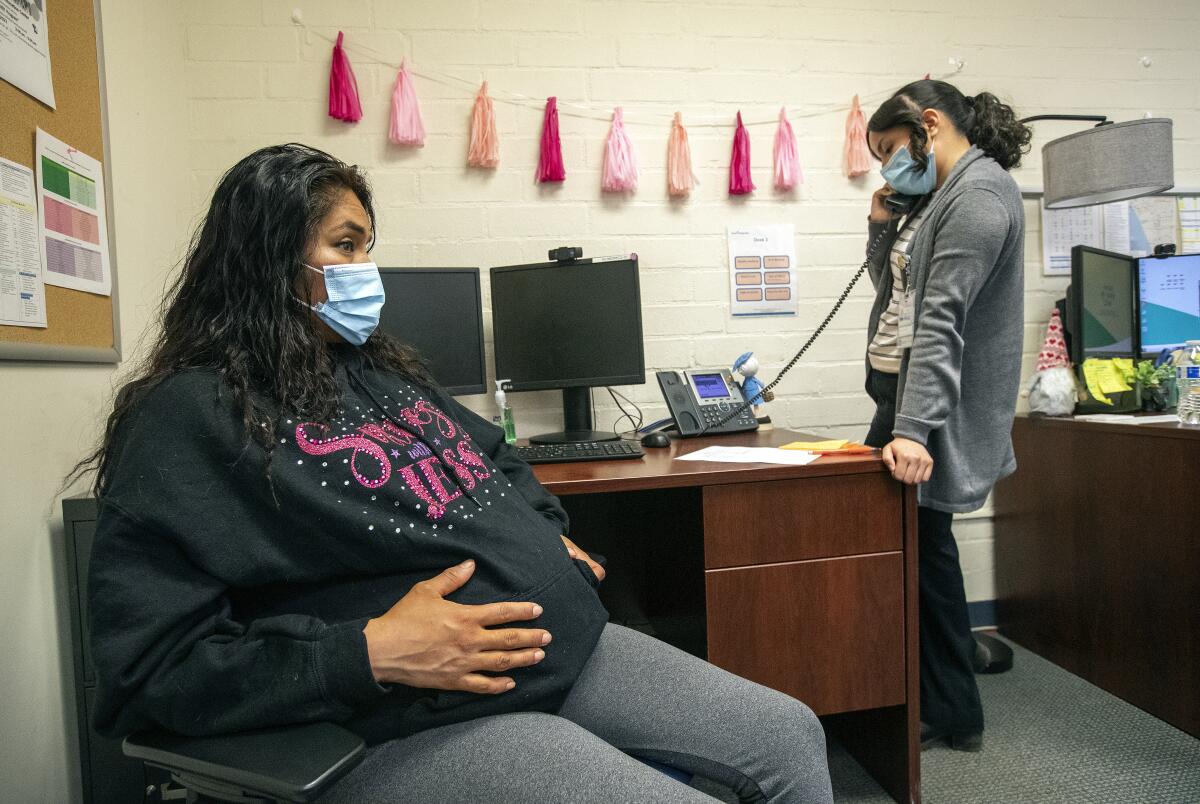 A plus-size woman sitting on an exam table in an Atlanta medical office in fall afternoon light