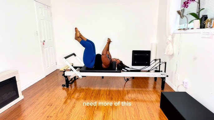 plus size woman supine on Pilates reformer footwork position