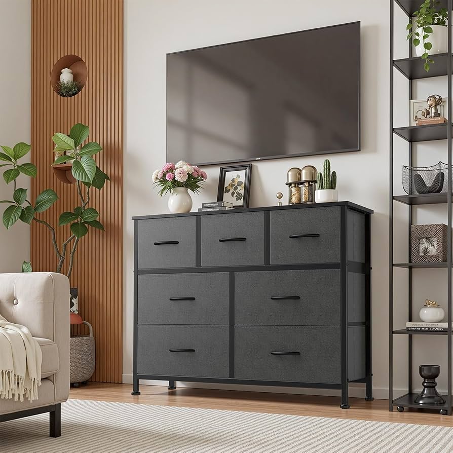 An open dresser drawer with acrylic Iris Drawer Dividers separating folded plus-size knit sweaters in cream, terracotta, charcoal, and navy by the file fold method