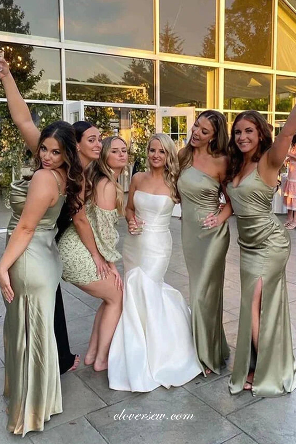 A sage green satin bridesmaid dress with thin straps on a curved dress form in soft natural light