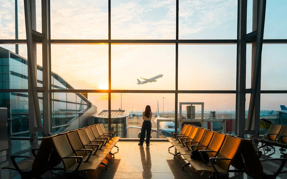 plus size traveler sitting in airport lounge chair morning light