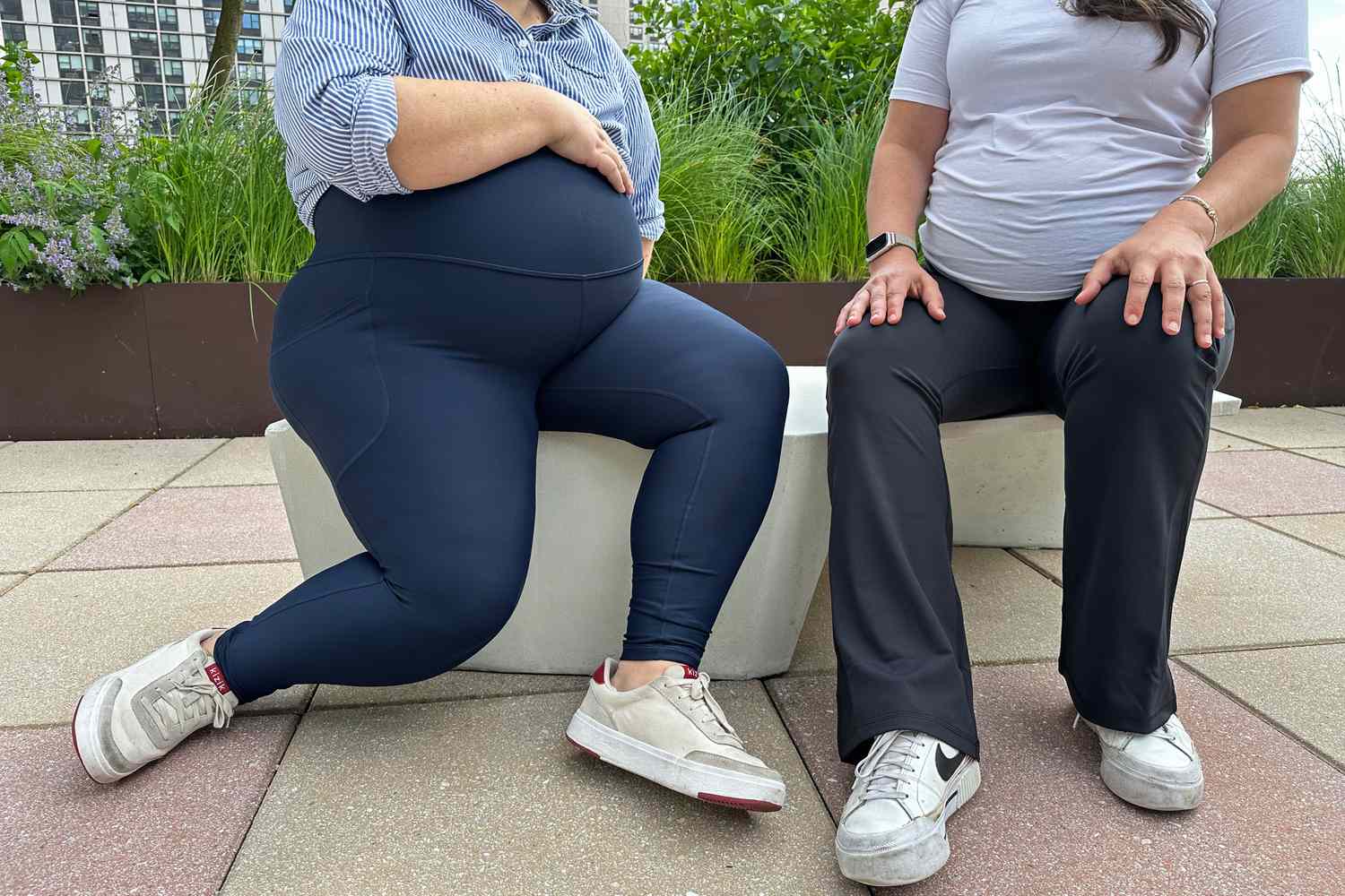 A plus-size pregnant woman walking on a residential sidewalk in soft late-afternoon light, one hand resting under the belly
