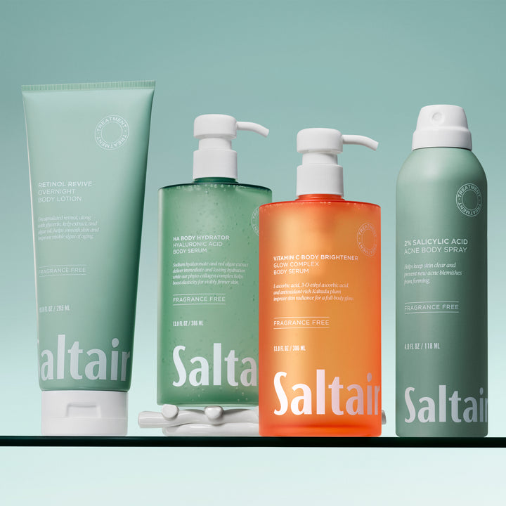 Flat lay of body skincare products including body serum, lactic acid lotion, KP bump eraser, and body sunscreen