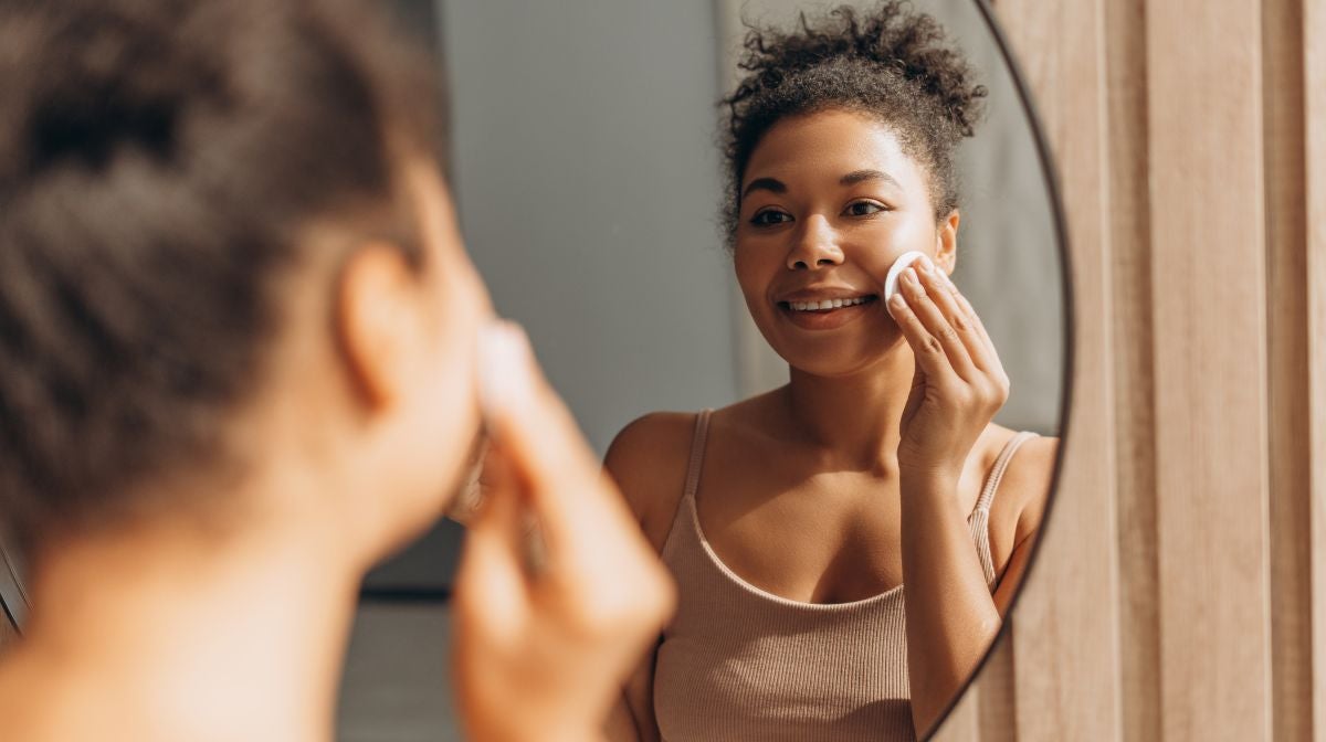 Black woman clear skin forehead bathroom mirror morning sunlight