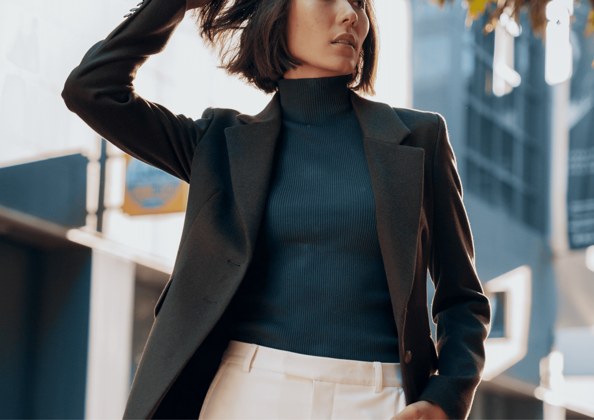 Black woman in tailored navy blazer holding one-page document outside glass conference room
