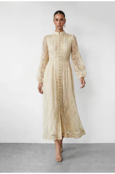 Tonal beige column outfit on a dress form in a Brooklyn fashion studio with steam pipe and natural light