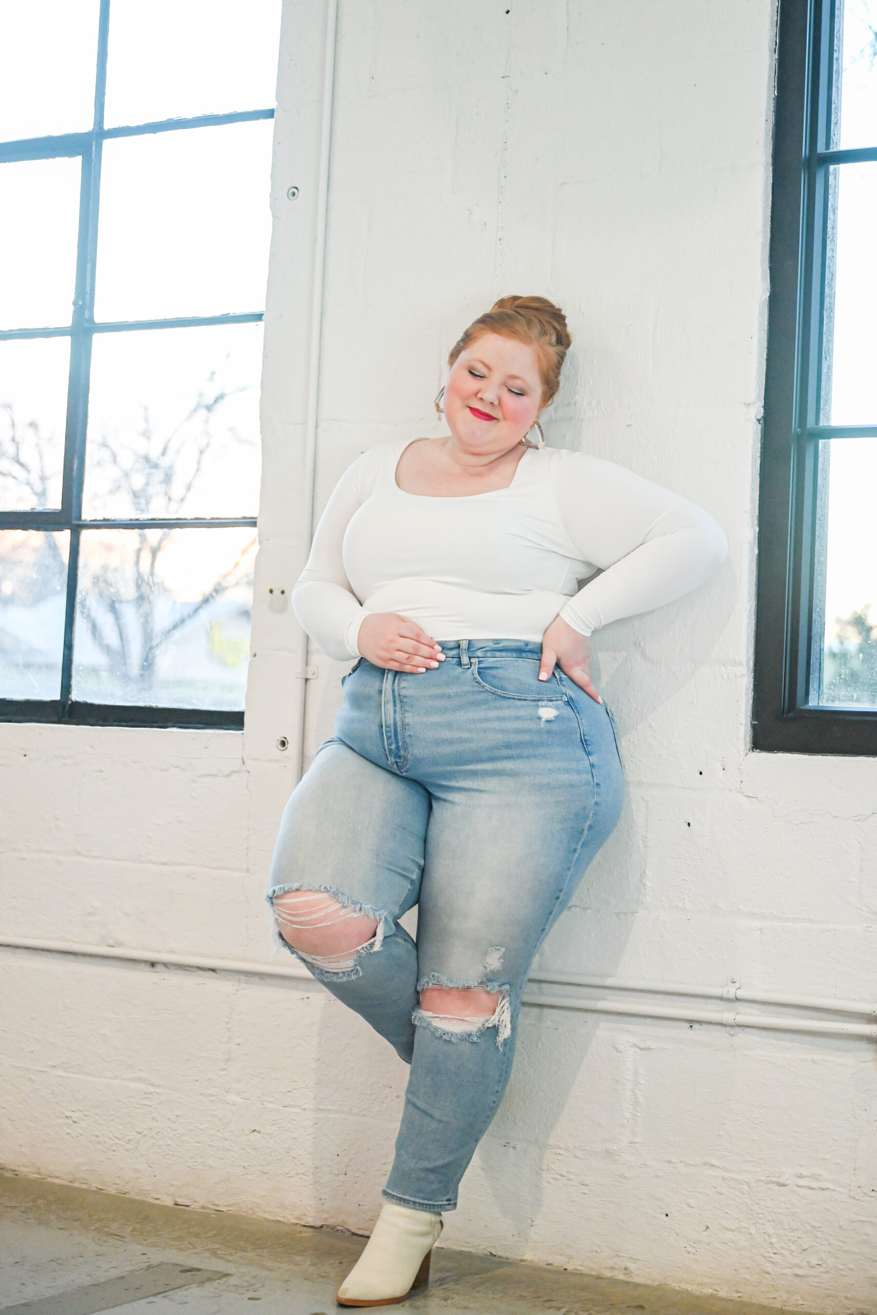 A plus-size woman wearing high-rise jeans that sit smoothly at her natural waist