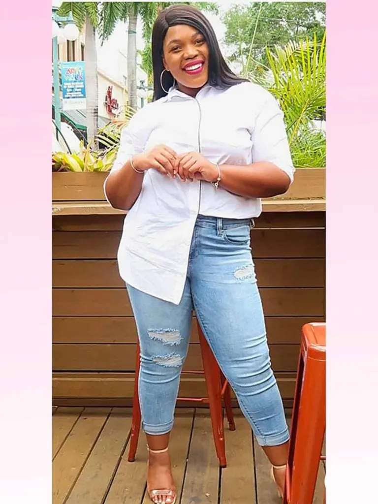 A plus-size woman wearing high-waisted jeans with a tucked-in top