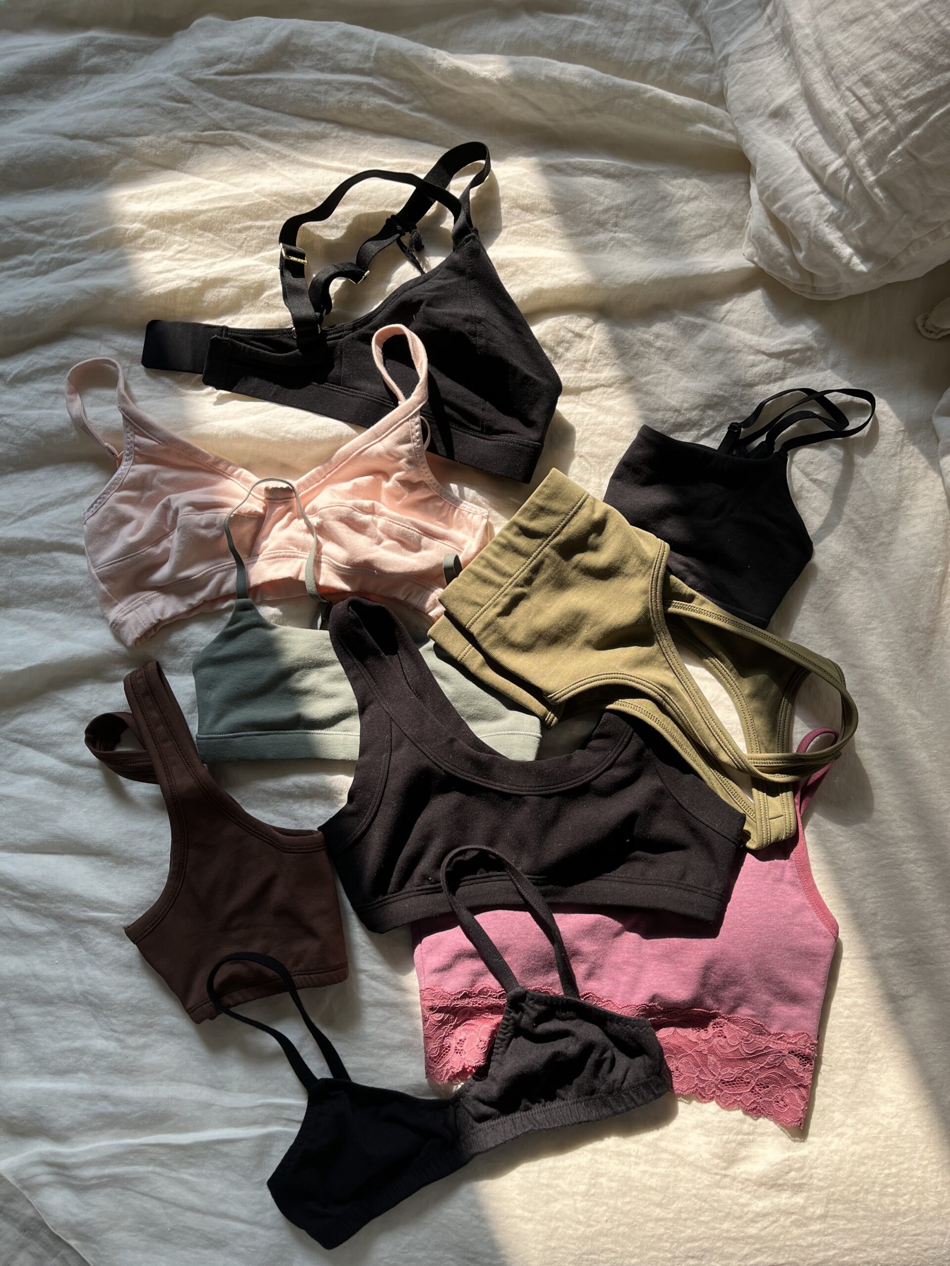 A selection of breathable cotton bras laid out on a bed