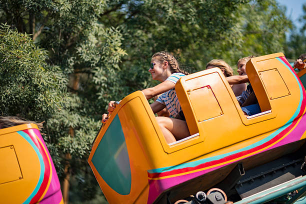Colorful amusement park with roller coasters and diverse families walking through