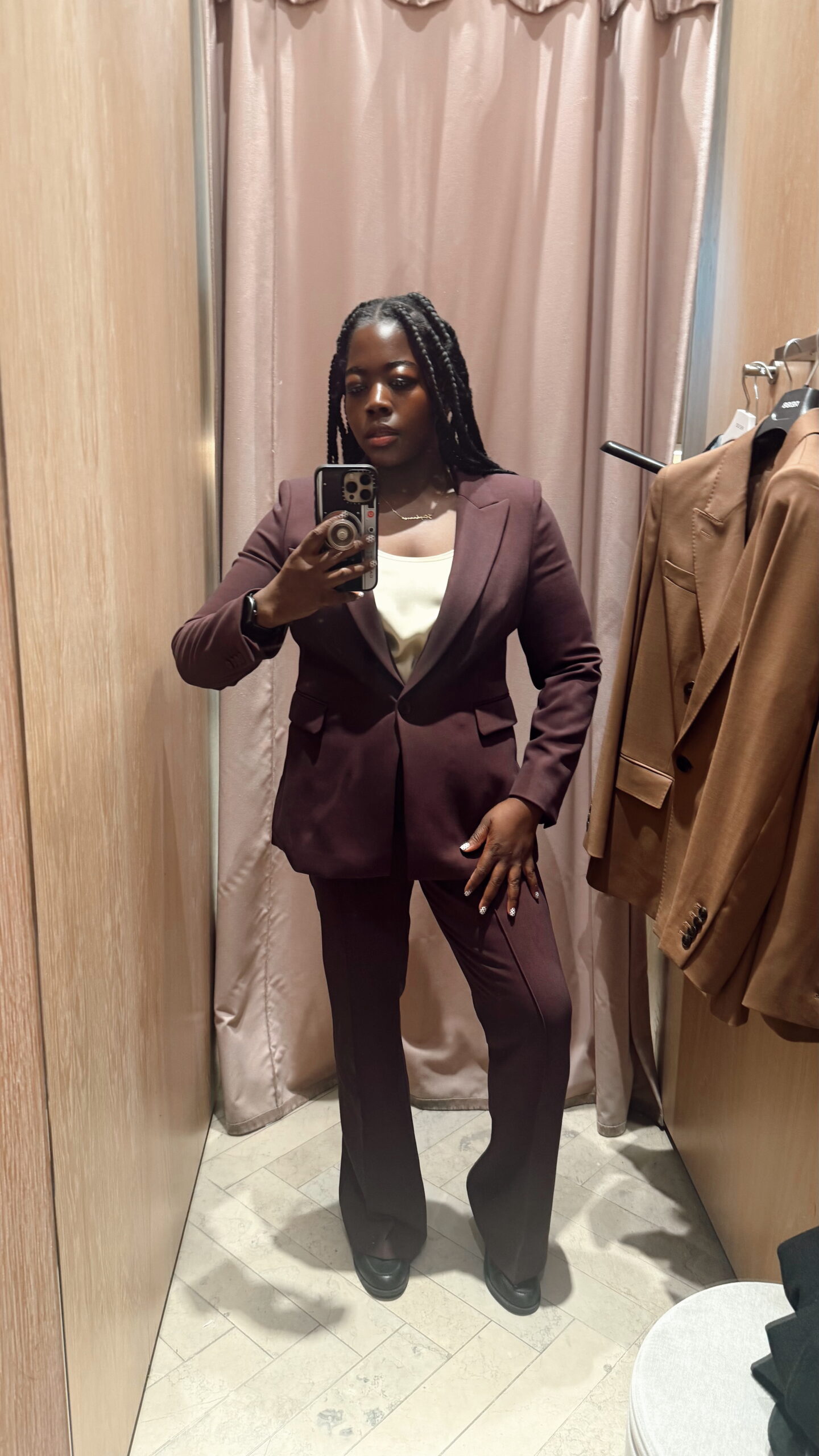 Confident plus size woman in a burgundy power suit in a modern office setting