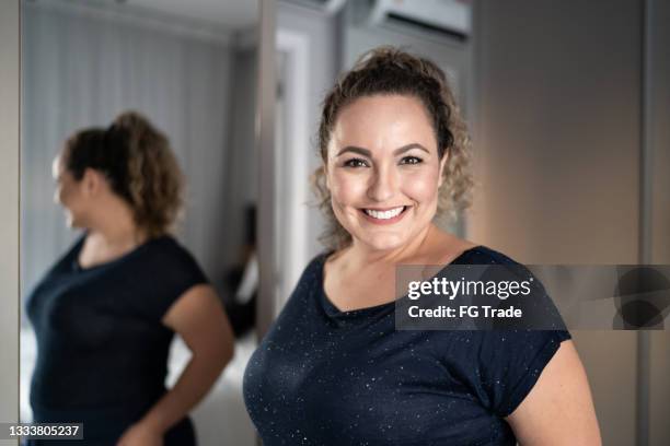 Diverse plus-size women smiling at their reflections in a mirror