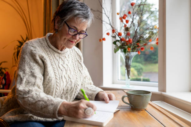 Plus-size woman journaling peacefully at a window desk during golden hour
