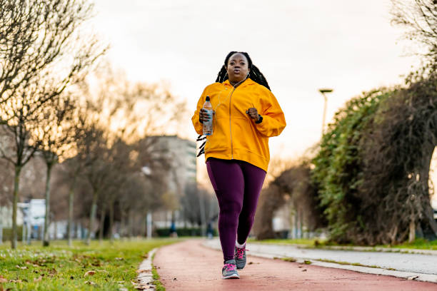 Plus-size woman walking briskly through rolling hills during golden hour