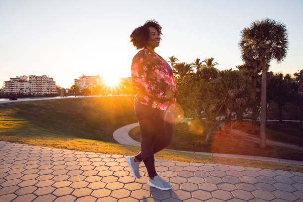 Plus-size woman walking confidently on scenic outdoor path in morning light