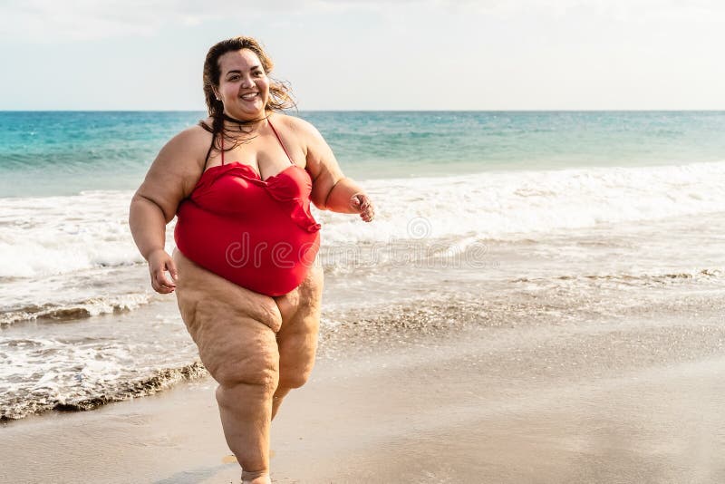 Plus-size woman with outstretched arms on a beautiful tropical beach