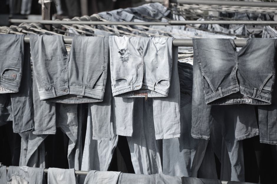 Several pairs of high-waisted jeans in different washes folded on a shelf