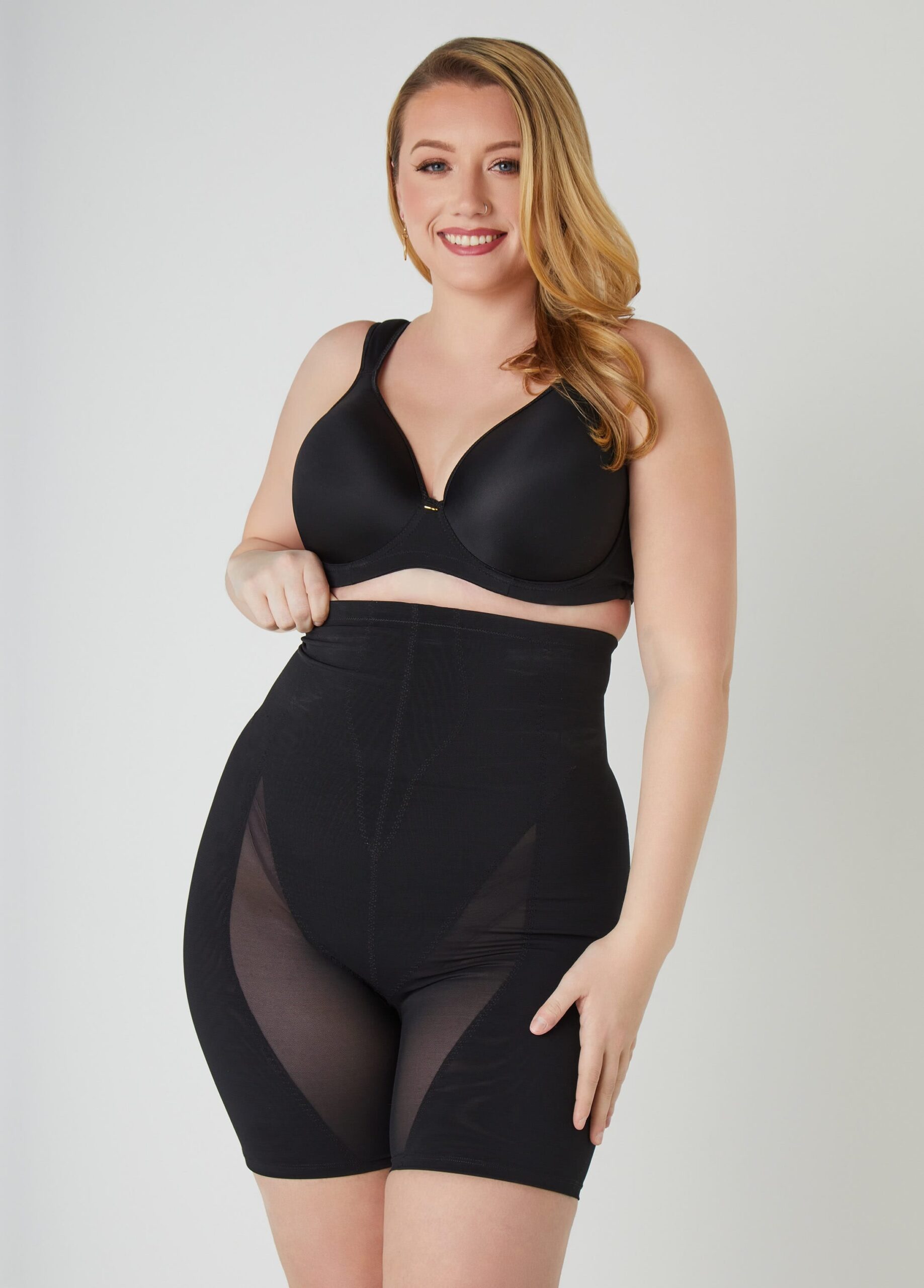 A plus-size woman in high-waisted shapewear that comes up to her natural waist