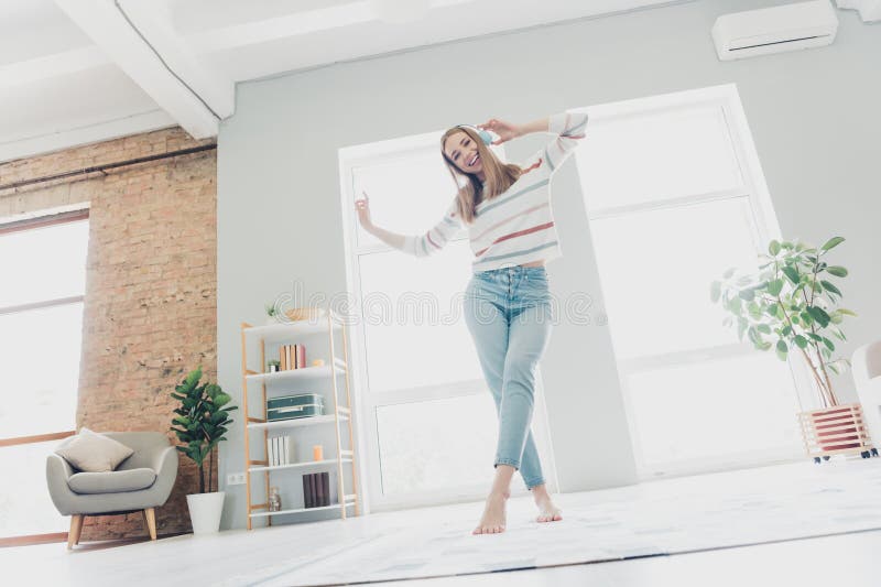 Woman dancing joyfully in her living room for a quick stress relief break