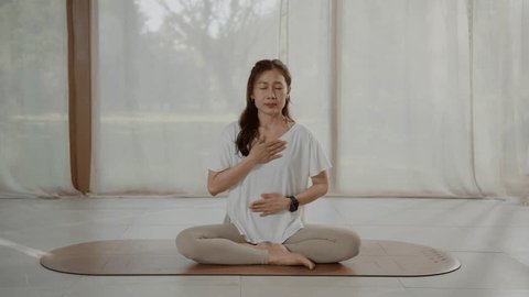 Woman practicing stress relief breathing in a calm, bright room