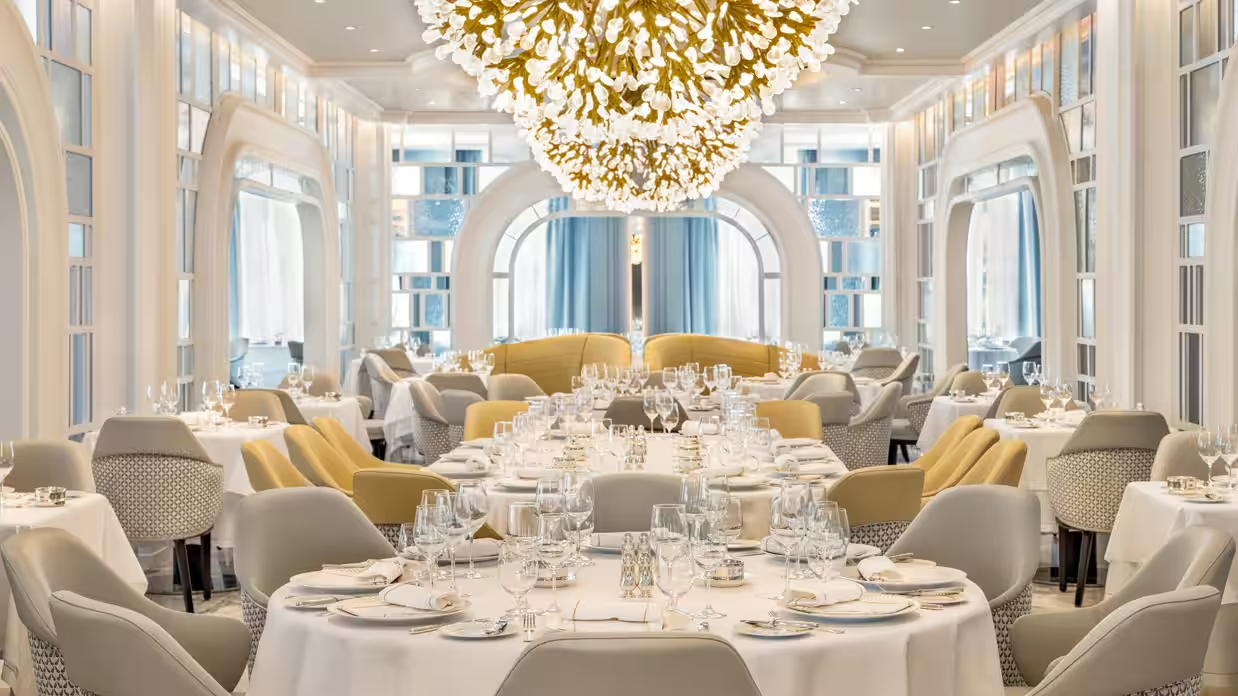 Elegant cruise ship main dining room set with upholstered chairs and white linens