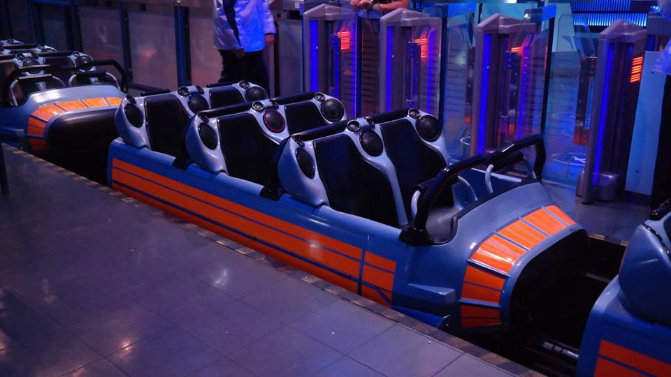 Empty roller coaster train sitting in a theme park loading station