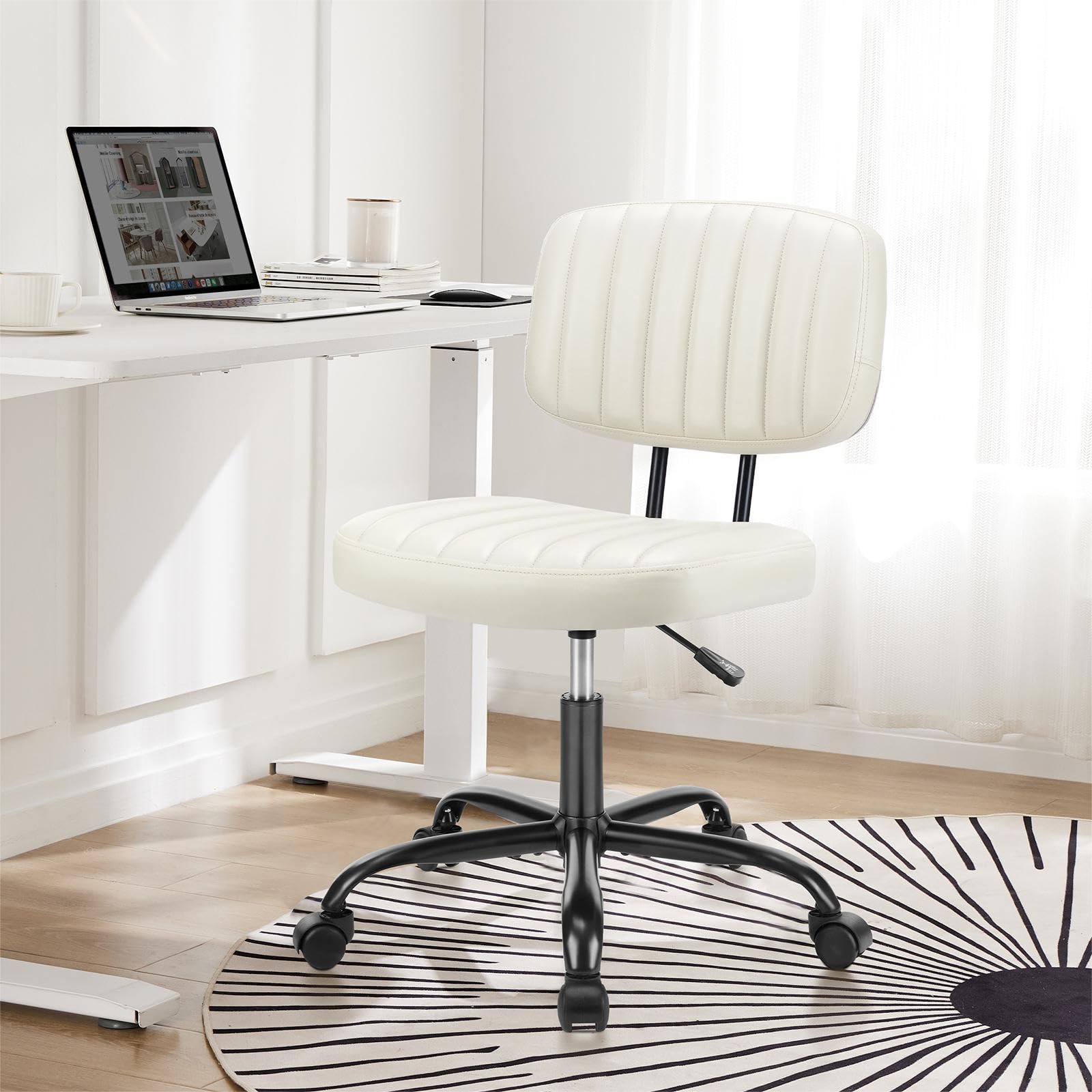 Home office desk with a simple armless chair and a laptop by a window