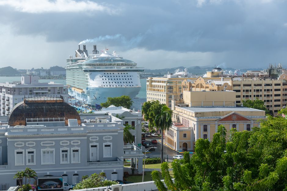 Large modern cruise ship docked in a sunny Caribbean port