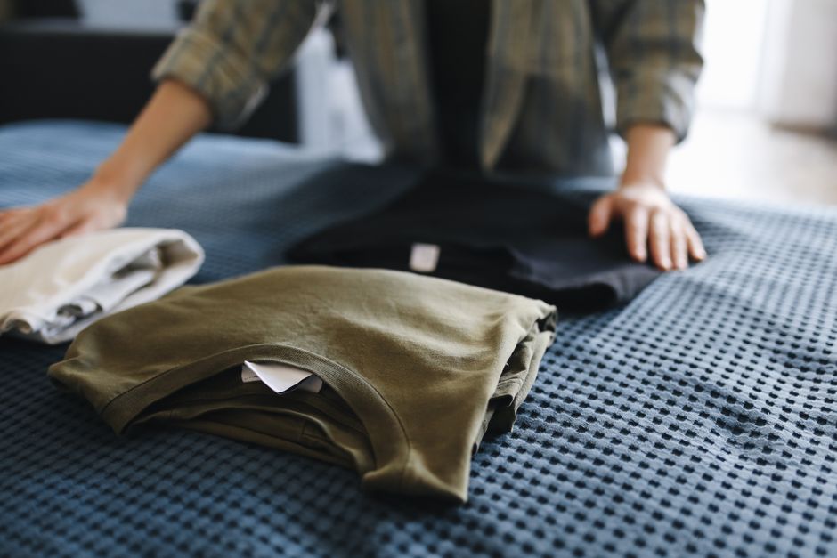 Neatly folded basic tops and leggings arranged on a bed