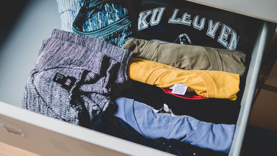 Neatly folded bras in neutral shades arranged in a drawer