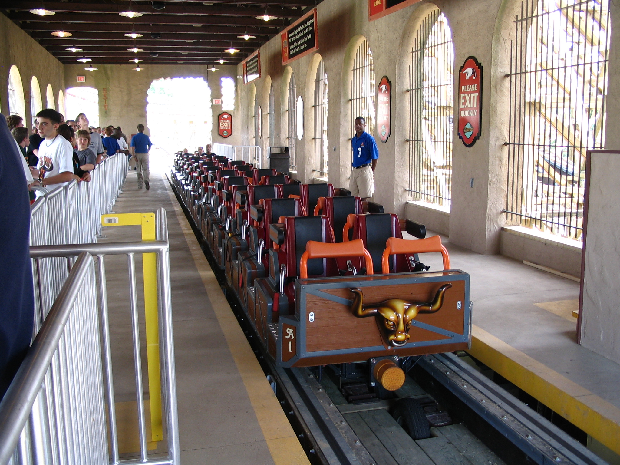 Rollercoaster train with over the shoulder restraints waiting at a station platform