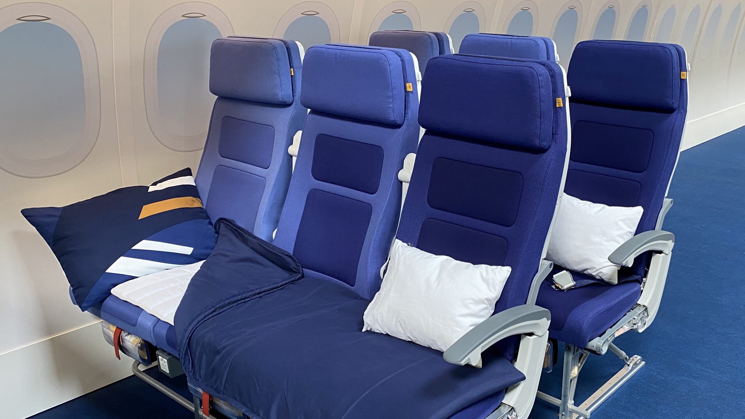 Row of economy airplane seats with armrests raised
